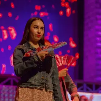 Alumna mueve abanico en interpretación musical para la obra 