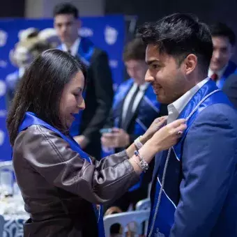 Maestra poniendo estola a graduado