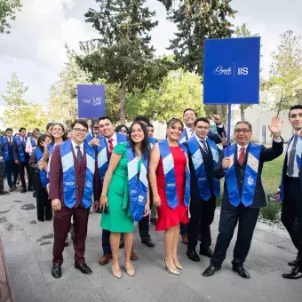 Graduados y graduadas posando al iare libre con profesores