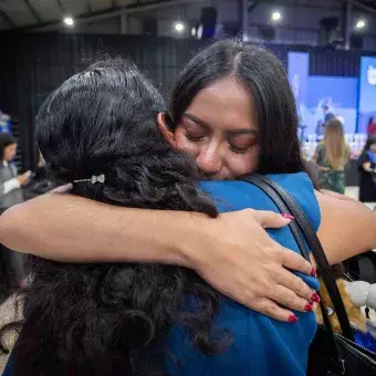 Madre y estudiante graduada abrazándose