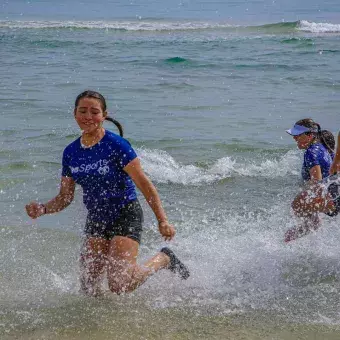 Alumnos divirtiéndose en la orilla de la playa