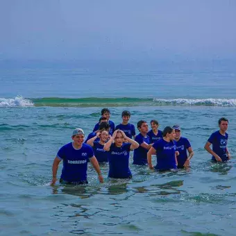 alumnos refrescándose en la orilla de la playa