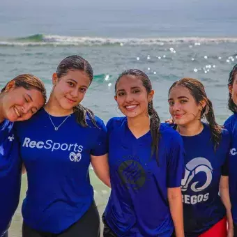 grupo de alumnas mirando a la cámara en la playa