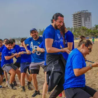 profesores jugando a la cuerda en la playa