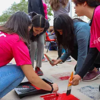 Trabajo en equipo mientras los alumnos pintan en Voluntariado Tec