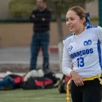 Quarterback del equipo femenil de tochito preparando jugada