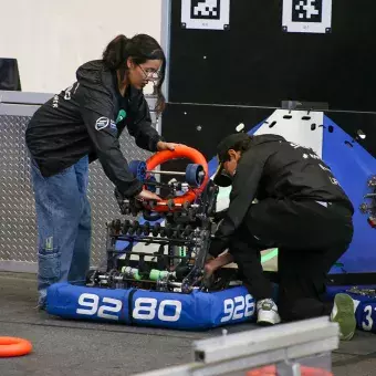 Alumnos colocando su robot en posición.