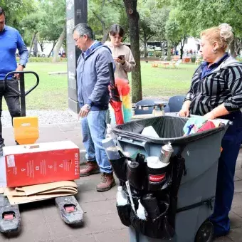 Colaboradoras llevan cartón para ser pesado.