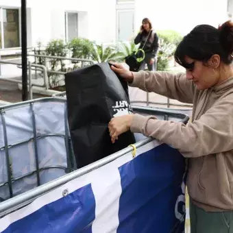 Mujer deja latas en depósitos de Reciclatec.