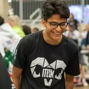 Estudiante con playera negra riendo