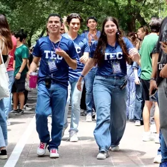 Alumnos celebran y corren a través de una valla.