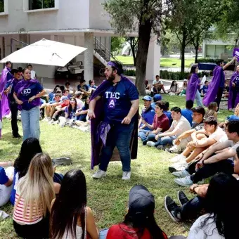 Alumnos sentados en círculo escuchando indicación de un estudiante.