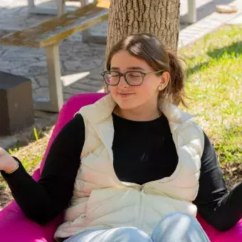 Estudiante meditando en jardín