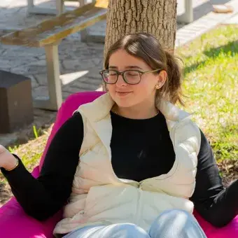Estudiante meditando en jardín
