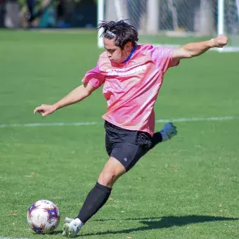 Jugador de futbol se prepara para patear el balón. 