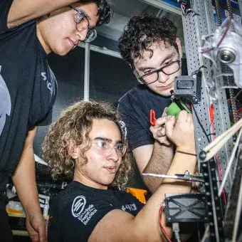 Jóvenes de PrepaTec Laguna trabajan en su robot durante la competencia Regional Monterrey de FIRST 2025