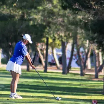Jugadora preparando su tiro en uno de los hoyos del recorrido.
