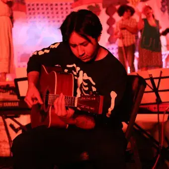 Alumno tocando la guitarra en el evento