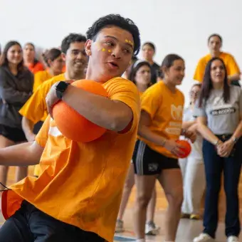 Estudiantes vestidos de amarillo jugando quemados. 