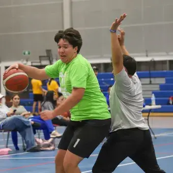Alumnos de preparatoria jugando básquetbol. 