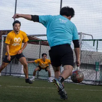 Alumnos universitarios jugando fútbol. 