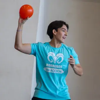 Alumno de preparatoria de perfil a punto de lanzar una pelota. 