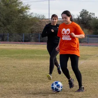 Alumnas universitarias jugando fútbol. 