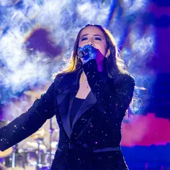 Cantante vestida de negro sobre el escenario.
